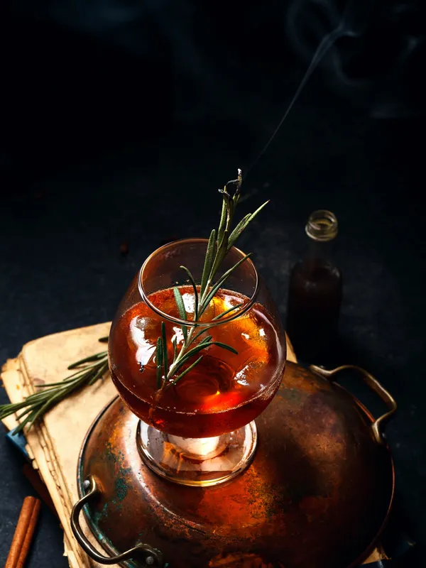 Smoked rosemary cocktail in a copper-lit setting